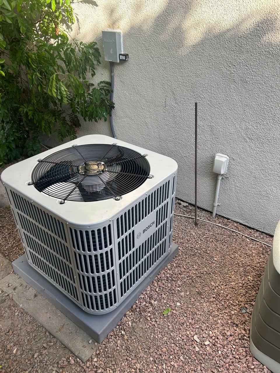 Bosch Light Series heat pump condenser installed on pad — outdoor unit