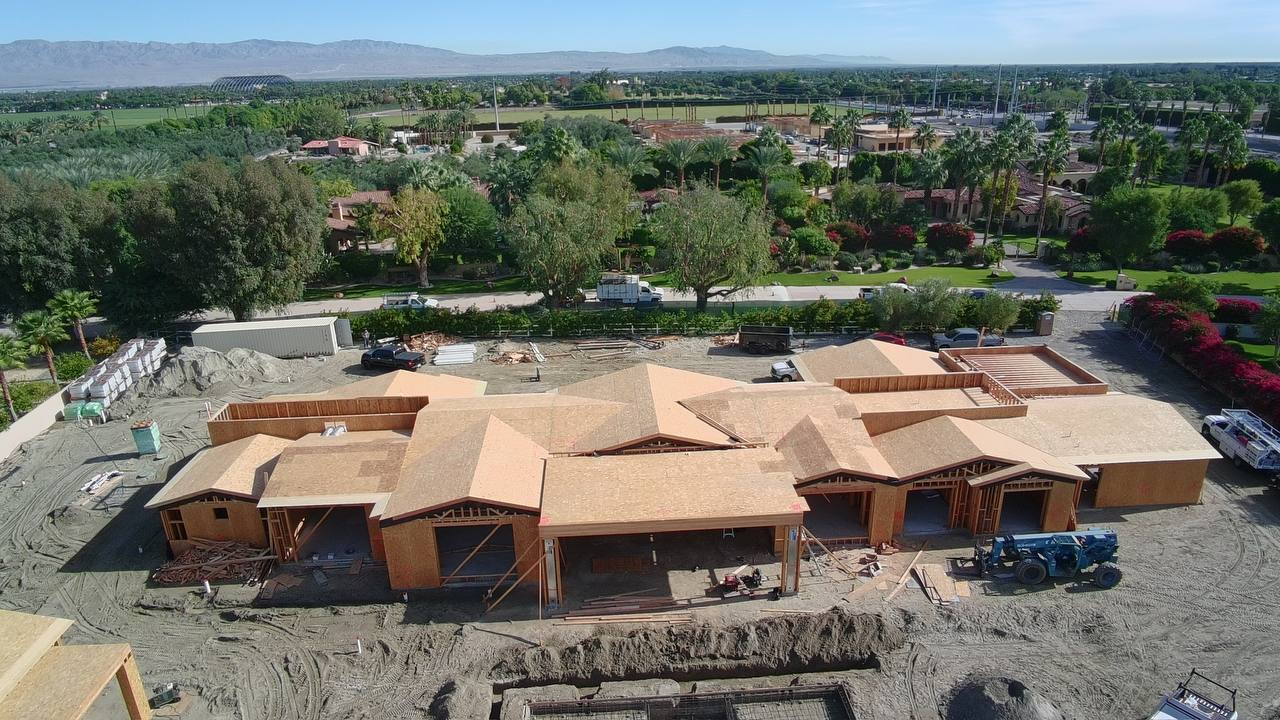Aerial overview of estate and barn structure during rough framing