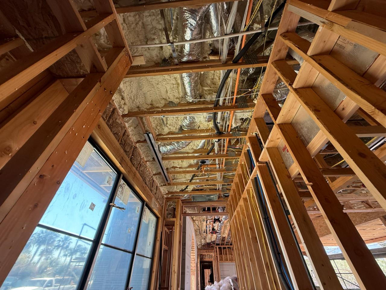 Main corridor of the residence showing full-length linear slot diffuser track and ductwork rough-in