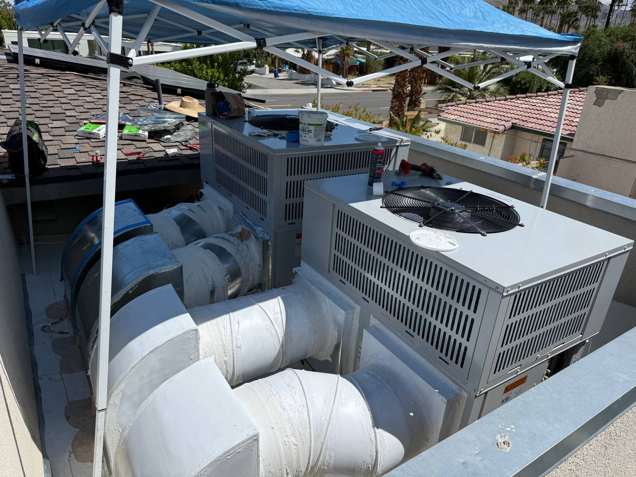 Installation day — both Bosch IDP units being set on new curbs, crew working under shade canopy